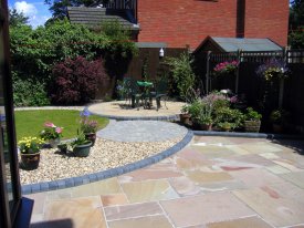 AFTER INDIAN STONE PATIO WITH CURVED THEMED GARDEN GRASSENDALE